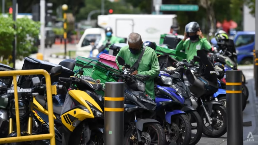 Delivery riders beside motorcycles